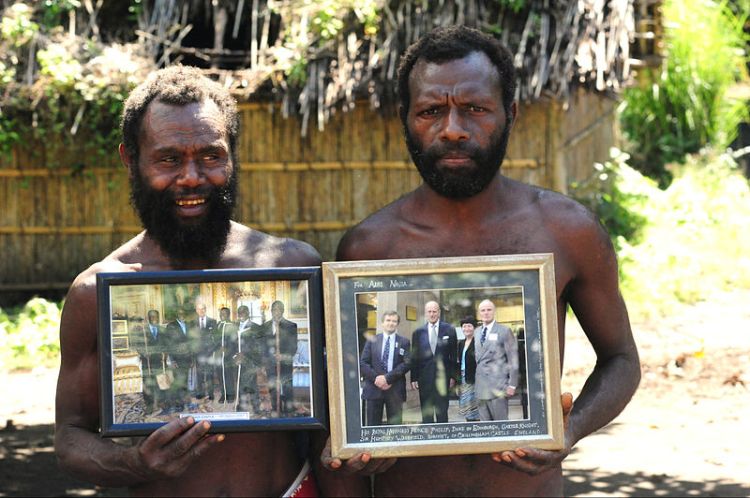 Two Yaohnanen Tribesmane proudly show off their photo of the 2007 royal visit with their god, Prince Philip. Photo by Christopher Thompson.