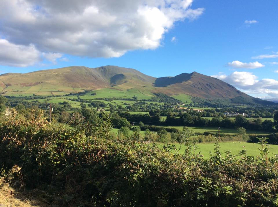 Skiddaw - 3,054 feet or 931 metres tall. My route would be to climb up through the wood in the centre and reach​ the ridge and then follow it round up and right to the peak opposite.
