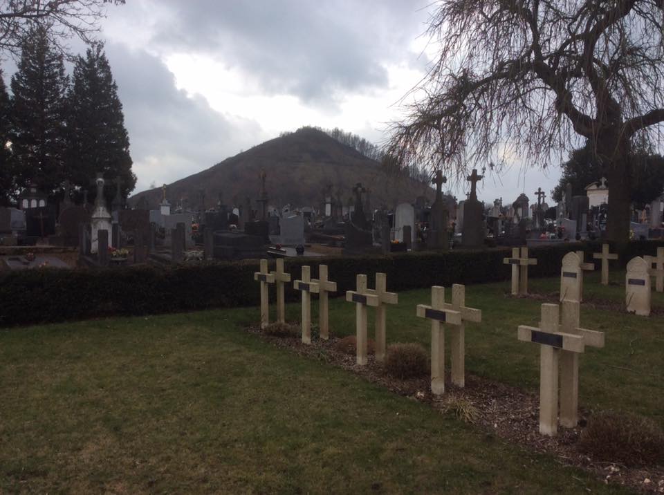 French military graves from WW1 in the foreground with 2 Algerian or Moroccan graves on the right next to the local communal cemetery under the shadow of a large heap of waste materials.