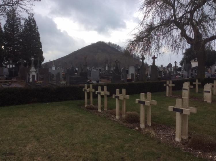 French military graves from WW1 in the foreground with 2 Algerian or Moroccan graves on the right next to the local communal cemetery under the shadow of a large heap of waste materials.