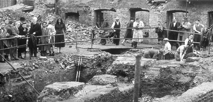 Excavation of the Temple of Mithras in 1954 Photo by Ivor Noel Hume. The bombed out buildings of WW2 clearly visible in the background.